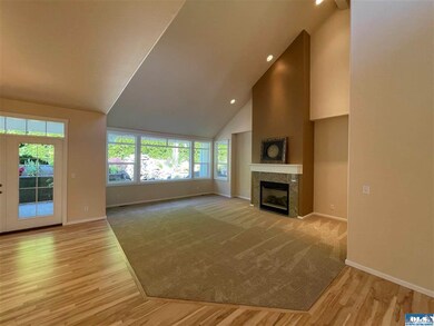 Hardwood floors surround carpeted living room - Picture window shows views of stone water feature!