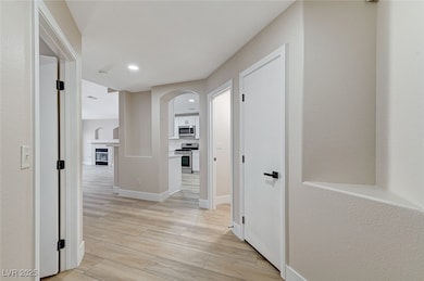 Hall with arched walkways, light wood-style floors