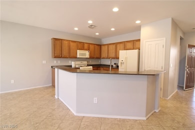 Kitchen featuring white appliances, dark counterto