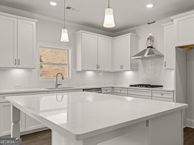 Westerly kitchen with white quartz countertops and white cabinets with crown molding