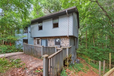 Back of property featuring a deck and stone siding
