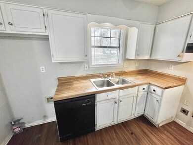 Kitchen featuring baseboards, black dishwasher, wh