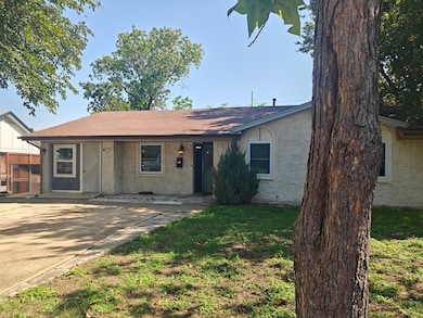 Ranch-style home with a front lawn, roof with shingles, and a porch