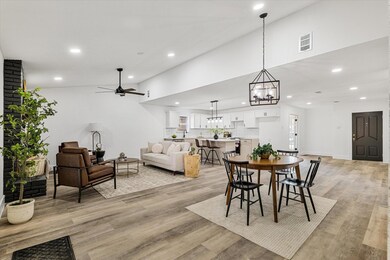 Dining room with ceiling fan with notable chandeli