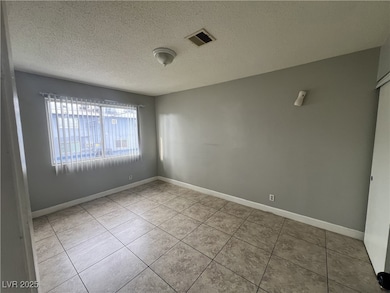 Empty room with baseboards, a textured ceiling, vi