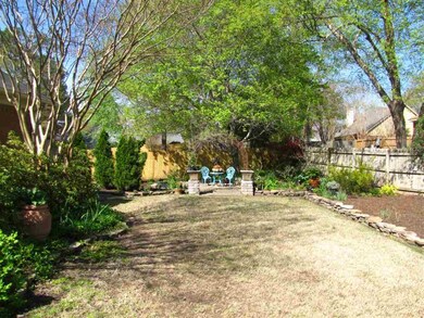 The beautiful backyard is surrounded by towering s