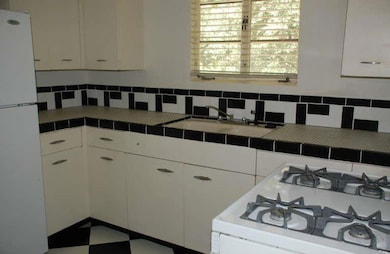Kitchen with white appliances, tile countertops, 