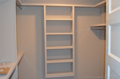 Master walk in closet with built in shelving.