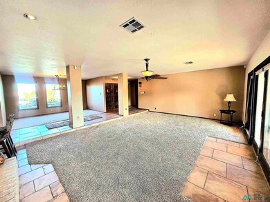 Unfurnished living room with light tile patterned floors, a textured ceiling, light carpet, and a ceiling fan