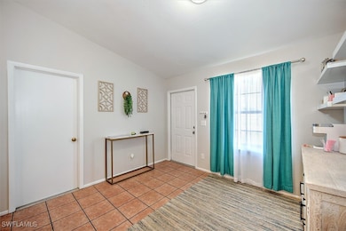 Entrance foyer with vaulted ceiling and light tile