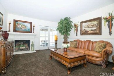 Accented with white wainscoting, the formal living room showcases a striking fireplace and custom mantel.