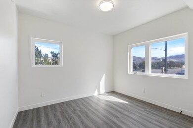 Empty room with wood finished floors, healthy amount of natural light, and a mountain view
