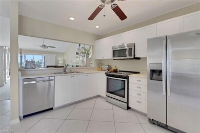 Kitchen with appliances with stainless steel finishes, white cabinetry, light countertops, open floor plan, and ceiling fan
