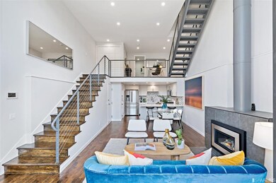 Spacious open concept living and dining area with abundant light, a modern gas burning fireplace with custom tile surround, recessed lighting, and sleek open staircases