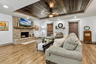 Living room featuring a brick fireplace, light har