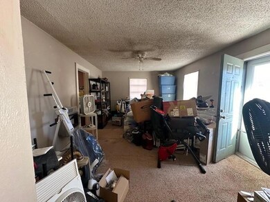 Office featuring ceiling fan, a textured ceiling, and light colored carpet