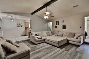 Living room with lofted ceiling with beams, visibl