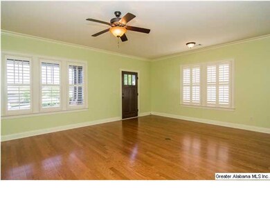 The spacious living room has hardwood floors, cust