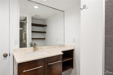 Bathroom with large vanity, built in shelves and updated shower.