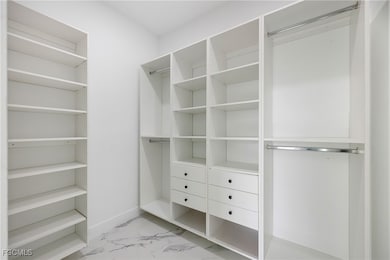 Walk in closet with light marble finish flooring