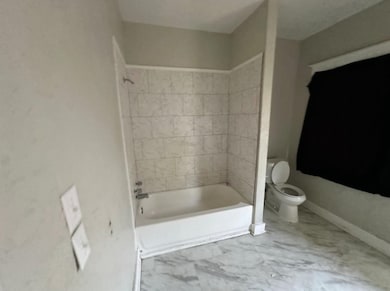 Bathroom with toilet and tiled shower / bath