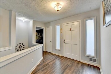 Entryway featuring visible vents, baseboards, dark