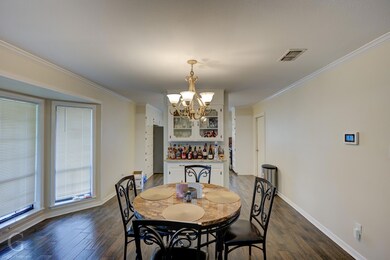 Dining area featuring crown molding, dark wood-typ
