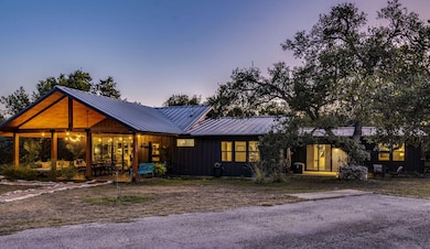 View of front of property with board and batten siding, a patio area, and a metal roof