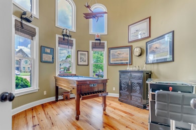 Versatile room with hardwood floors, plenty of natural light, and a high ceiling. Currently being used as a game room and could be a great office.