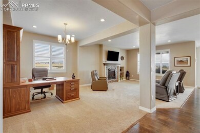 Carpeted living area with office and great room is adjacent to kitchen.