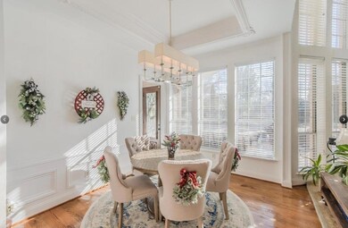 Dining space featuring wood-type flooring, an inviting chandelier, and crown molding