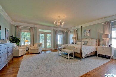 Spacious master bedroom with sitting area, hardwood floors, two huge walk-in closets with built-in cabinets, and glamour bath.
