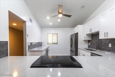 Kitchen with stainless steel fridge, light stone c