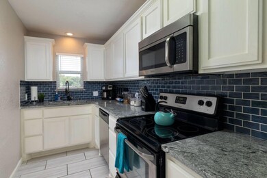 Kitchen with stainless steel appliances, sink, tas