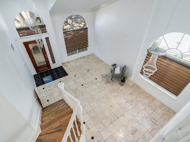Foyer entrance with a chandelier and ornamental m
