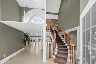 Tiled foyer entrance with ornate columns, a chande