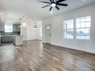 Unfurnished living room featuring ceiling fan with
