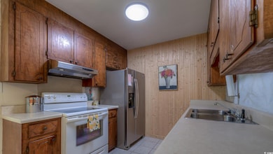 Kitchen with stainless steel fridge, sink, white e