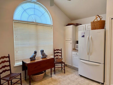 Office area featuring lofted ceiling, a ceiling fan, healthy amount of natural light, light tile patterned flooring, and a textured ceiling