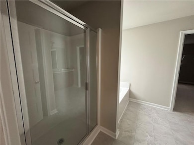 Full bath featuring a shower stall, a bath, baseboards, and marble look tiles