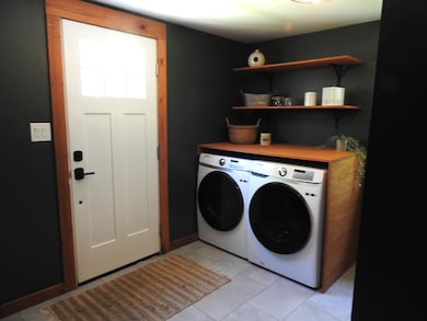 Front door with laundry area behind door when it is opened
