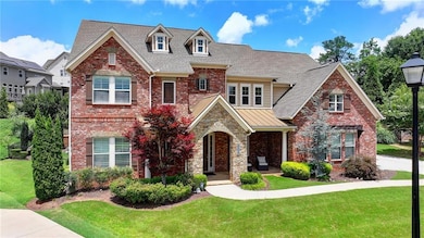 View of front of house featuring a front yard, roof with shingles, brick siding, and a standing seam roof