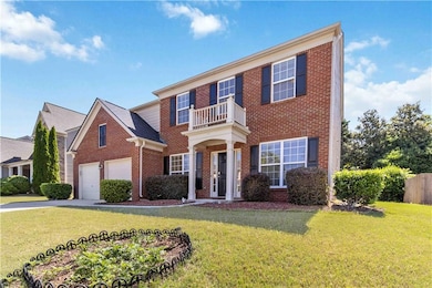 Colonial home featuring brick siding, a balcony, d