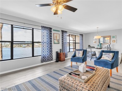 Living room featuring a water view, ceiling fan, b