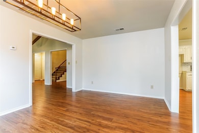 Spare room featuring a notable chandelier, stairwa