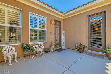 View of exterior entry with stucco siding and a pa