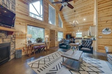 Living room featuring a stone fireplace, wood wall