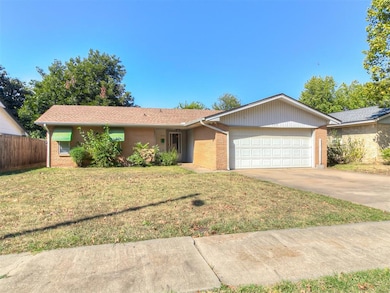 Ranch-style house featuring a front lawn and a gar