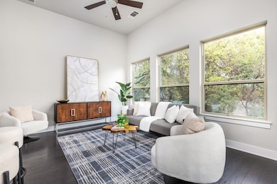 Living room with a ceiling fan, dark wood-style f