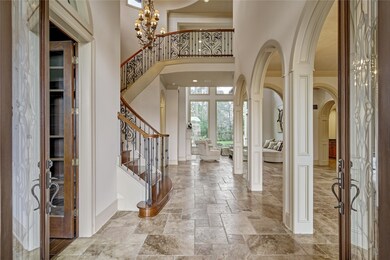 Double wood and glass doors. 10' tall a very special size doors for a magnificent entrance. Travertine floors through the house.